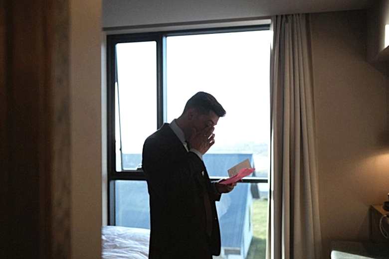 Groom reading card, crying