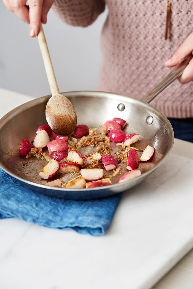 a woman cooking dinner from blue apron