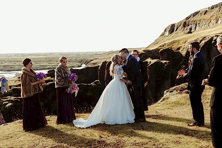 Bride and groom kissing in wedding ceremony in Fjaðrárgljúfur