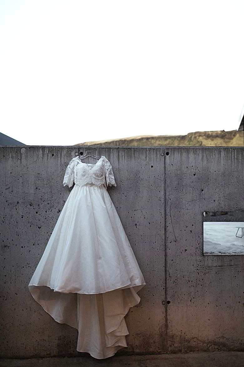 Wedding dress hanging on cement wall