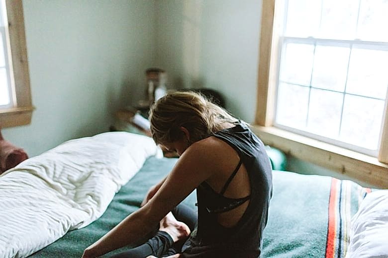 Woman meditating on her bed