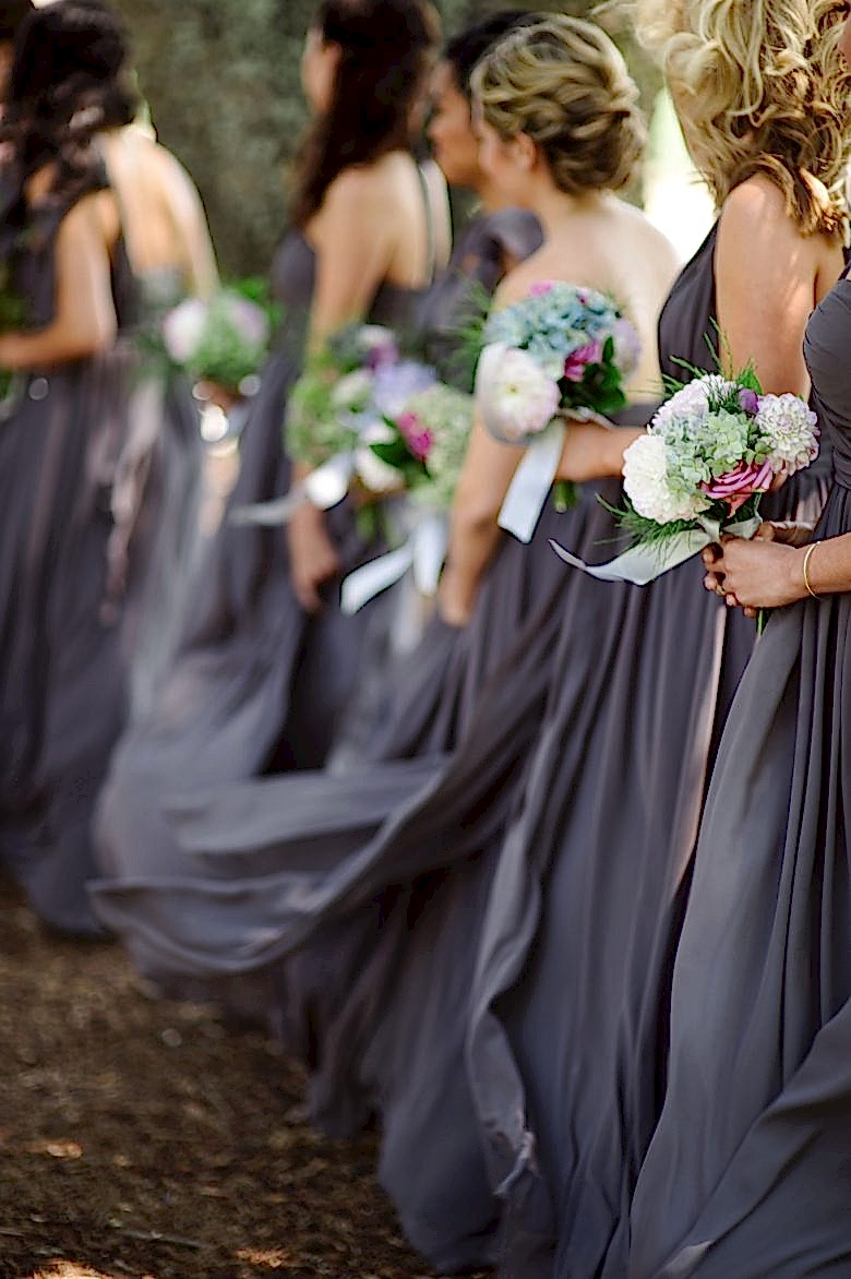 Bridesmaids in grey dresses, holding bouquets