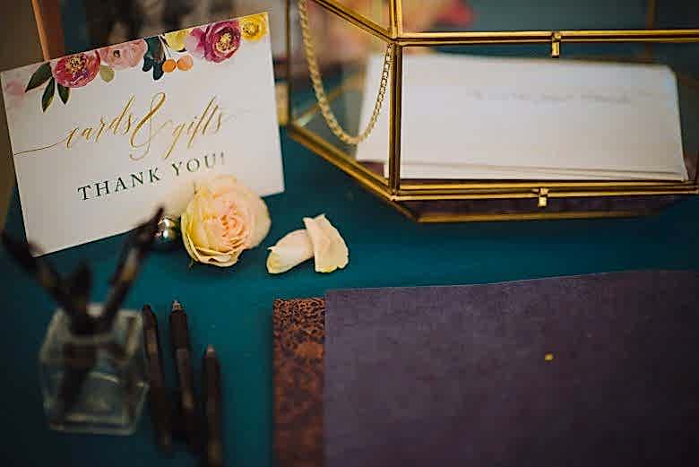 Cards and Gifts colorful floral sign by Bojack Studios on table with flower, box, and pens 