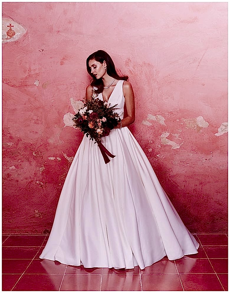 Woman holding bouquet and wearing Satin Ball Gown Wedding Dress