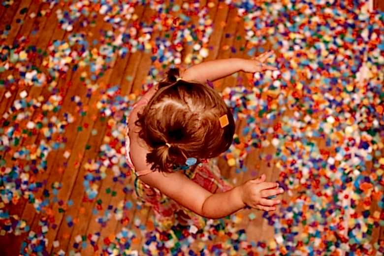 Overhead view of small girl with pigtails playing in confetti