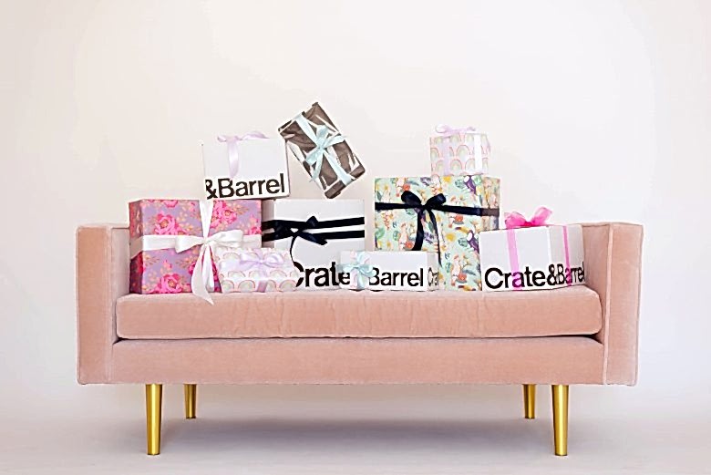 crate and barrel gift boxes and other wrapped gifts on pink velvet love seat