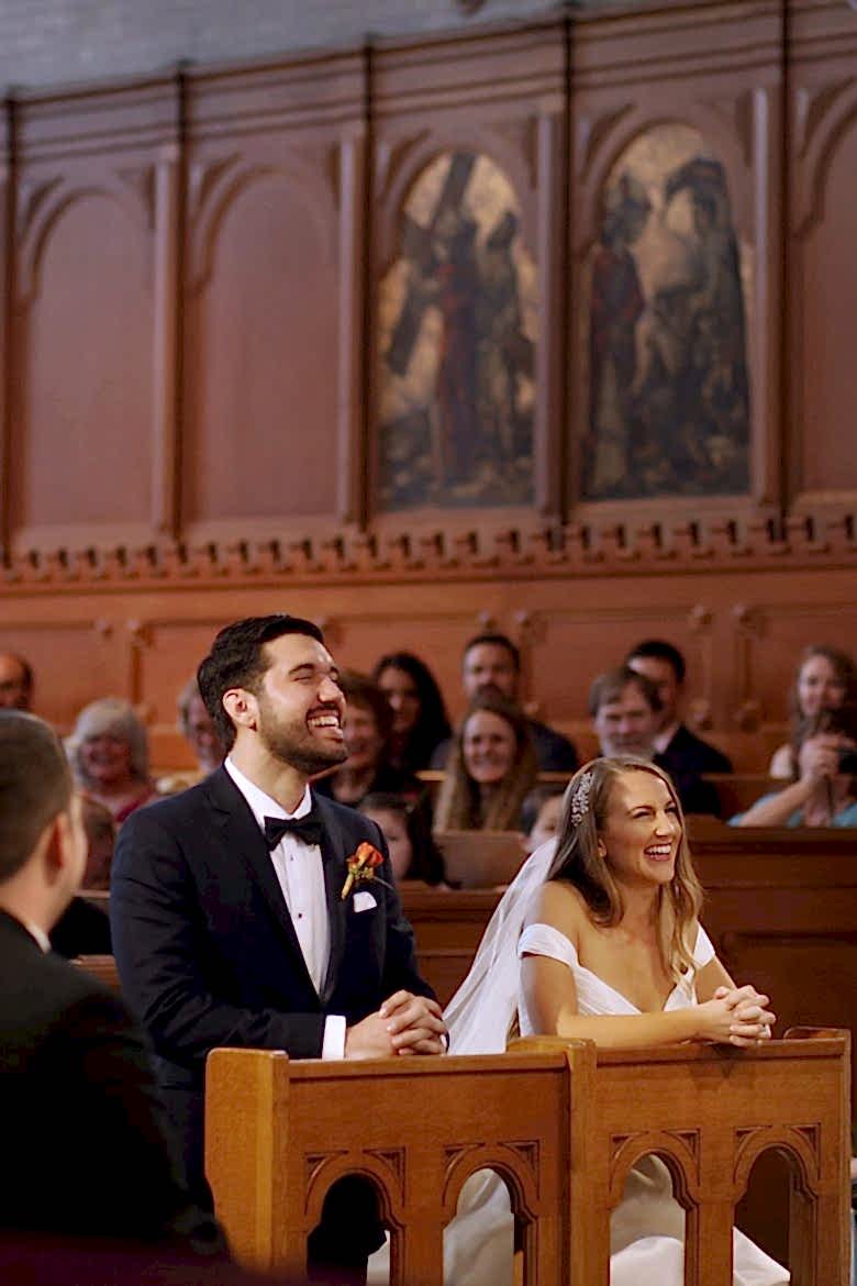 Bride and groom kneeling at church wedding, laughing
