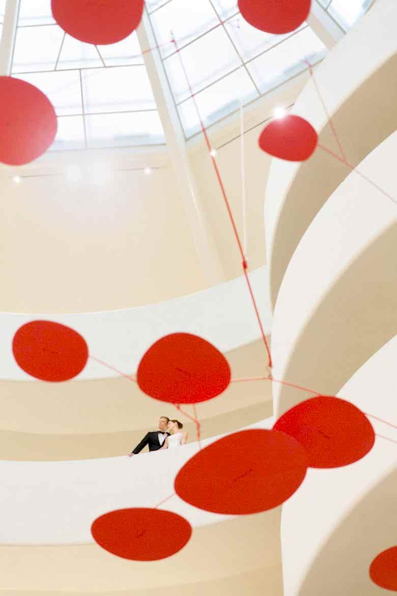 Bride and Groom in Guggenheim landing beyond Alexander Calder large red mobile