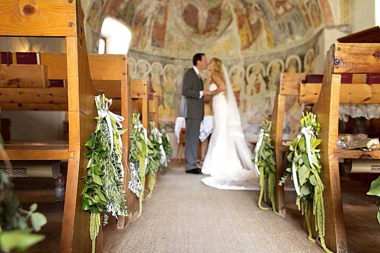 bride and groom kissing at altar
