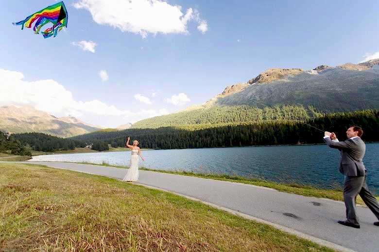 Bride and groom flying a rainbow kite