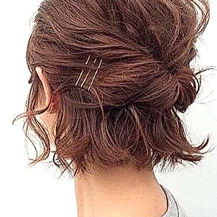 woman's chin-length hair from behind, pulled back into a loose horizontal twist, with three contrasting bobby pins as accent