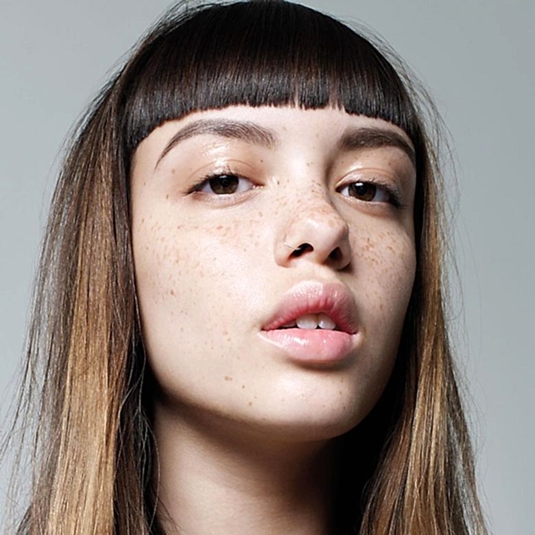 A woman with excellent bangs gazes deeply at the camera