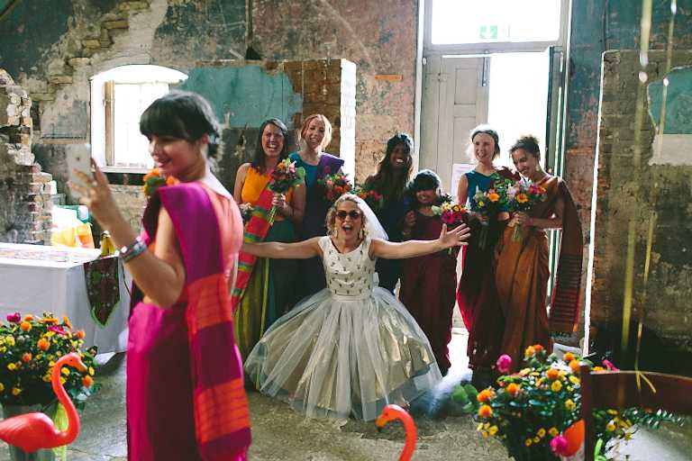 Bride in front of bridesmaids in bright saris