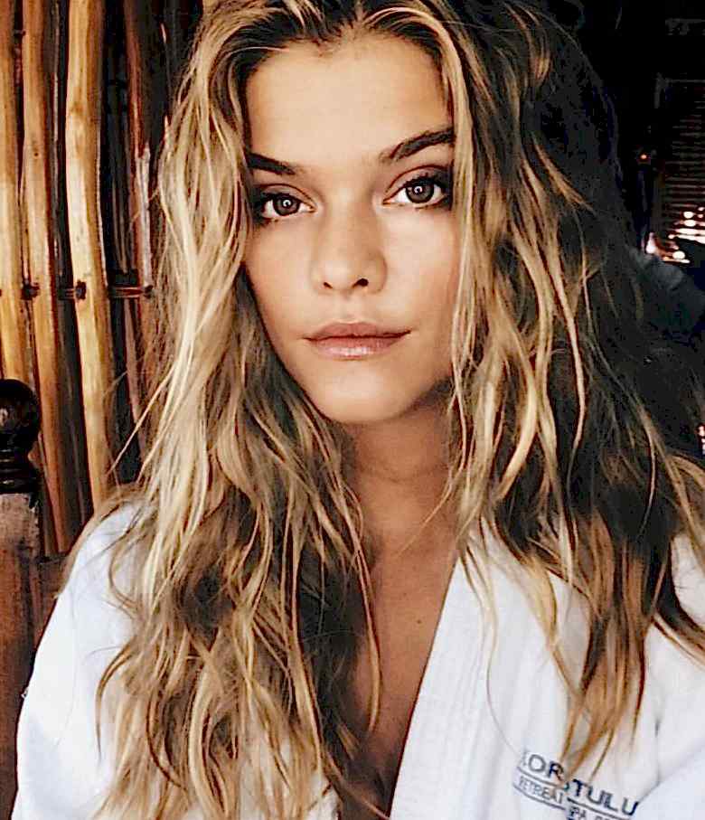 A woman with blond highlights confidently looks back at the camera