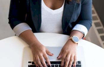 Woman's hands typing on a laptop