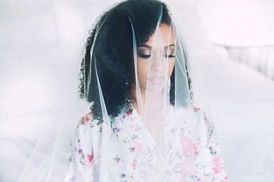 woman covered in veil with shoulder-length natural curly hair 