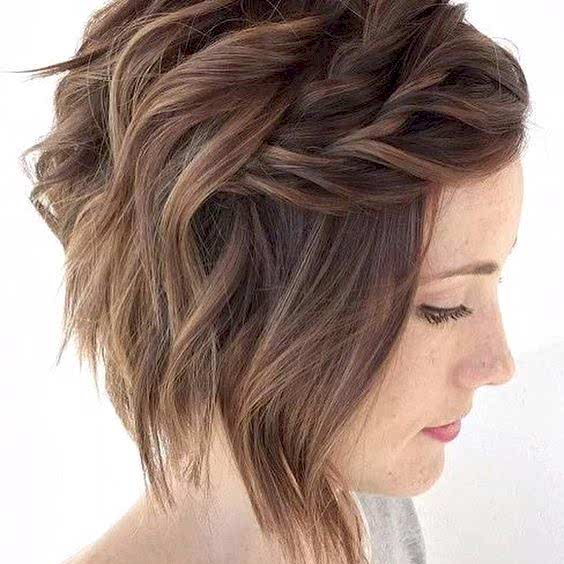 Woman with auburn hair in messy chin-length bob with two chunky, loose headband-style braids across the front, secured underneath hair