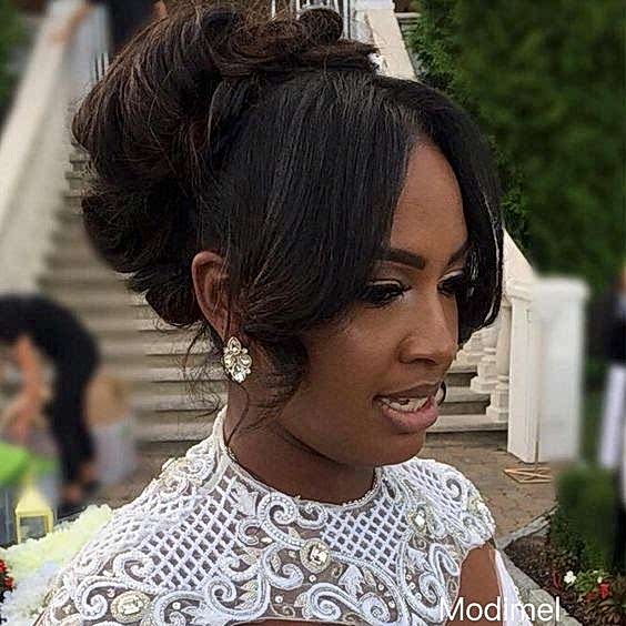 woman with front, chin-length hair parted center and loosely curled, with long hair curled and piled on the back of her head