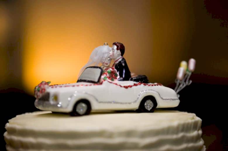 Photo of a caketopper of a wedding couple in a car