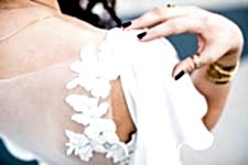 Closeup of a woman resting her hand on her right shoulder.