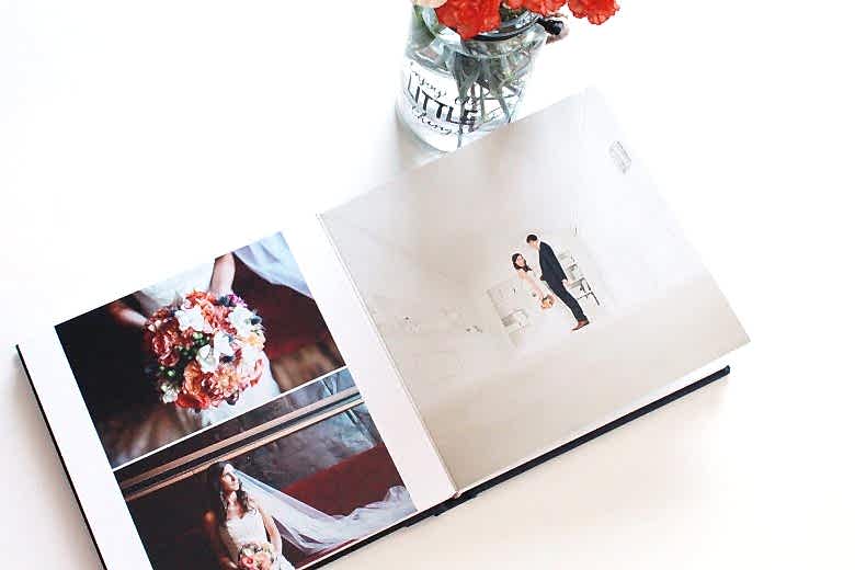Interior 3-image spread of wedding album next to vase of flowers