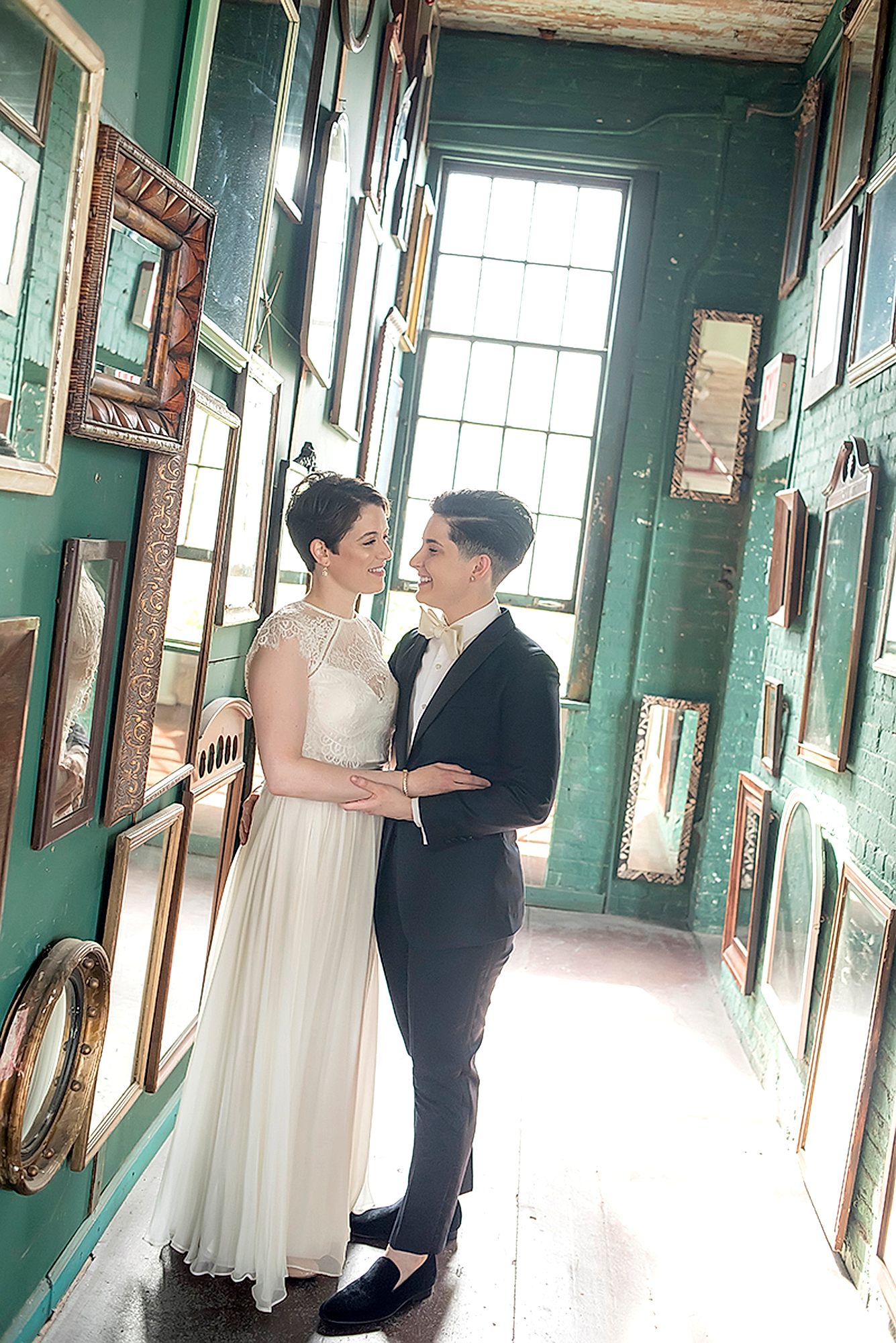A wedding couple pose in a hall of mirrors 