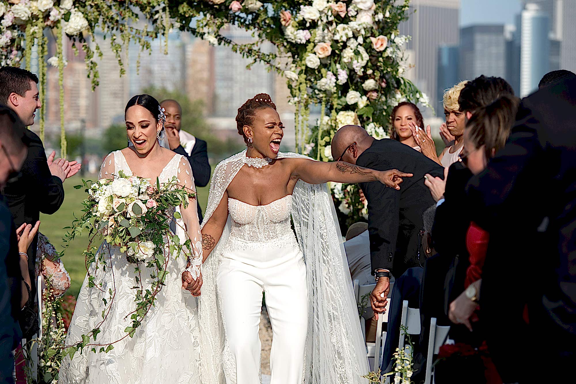 Two women walk back down the aisle after their wedding ceremony