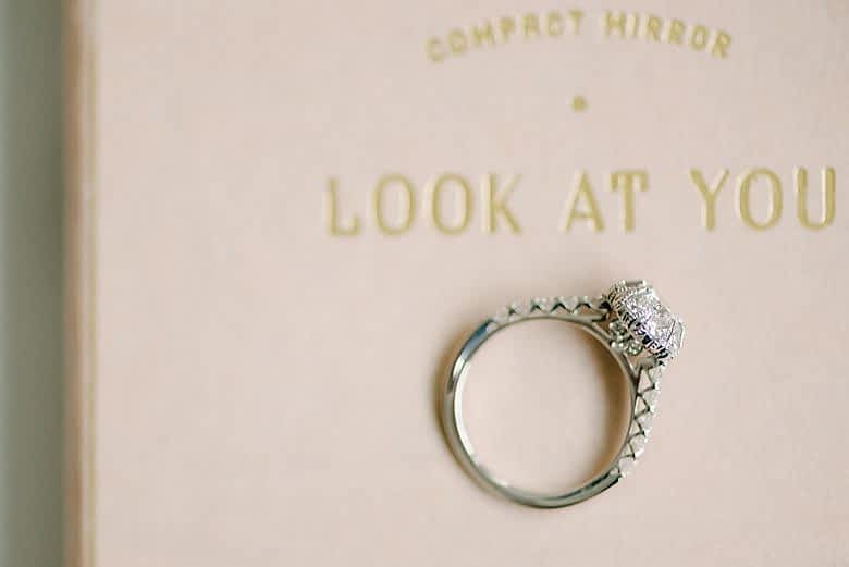 vintage halo macy's star signature diamond engagement ring sitting on a compact