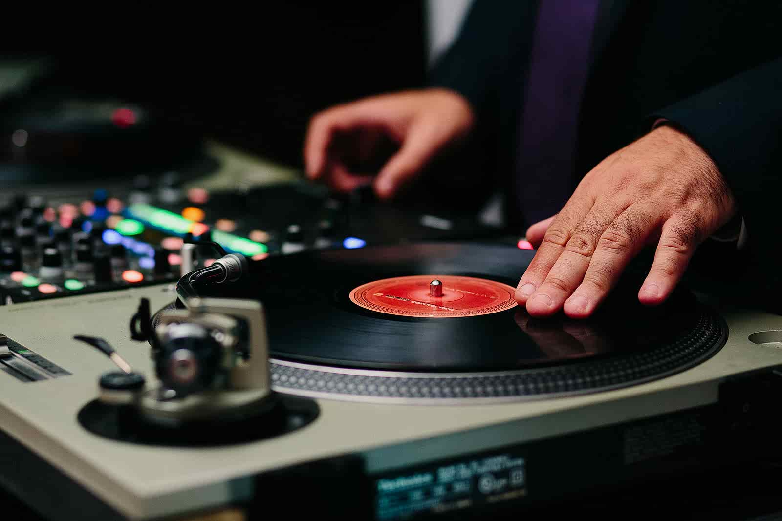 close up image of wedding DJ spinning records on a turntable