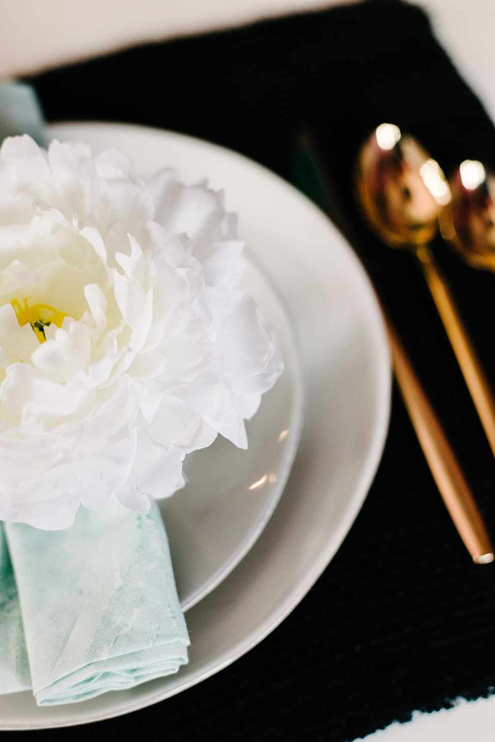 close up of white peony napkin ring on marbled watercolor napkins from crate and barrel