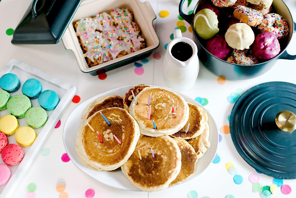 table filled with candy and breakfast food in crate and barrel serveware and graphite le creuset