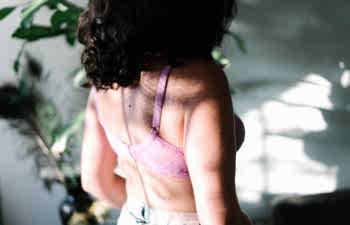 Back of a woman wearing a pink bra
