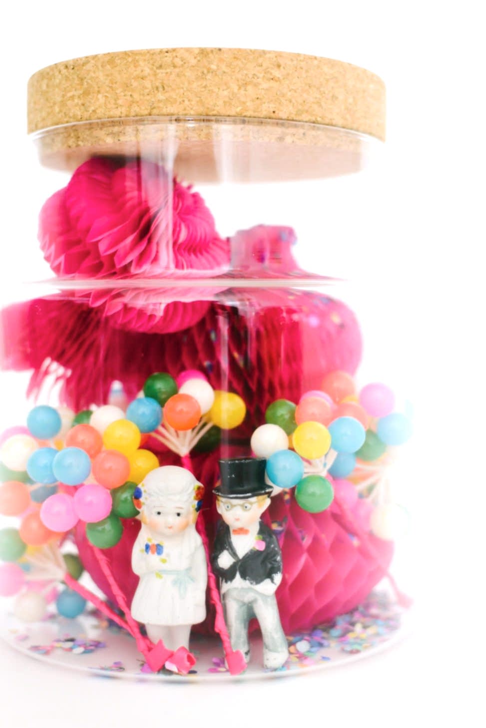 wedding party terrarium with pink and yellow mini pinatas and little people