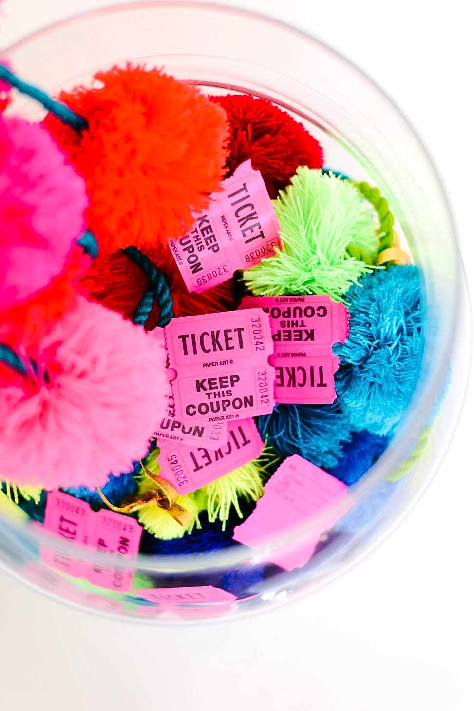 wedding party terrarium with pink and yellow mini pinatas and poof balls