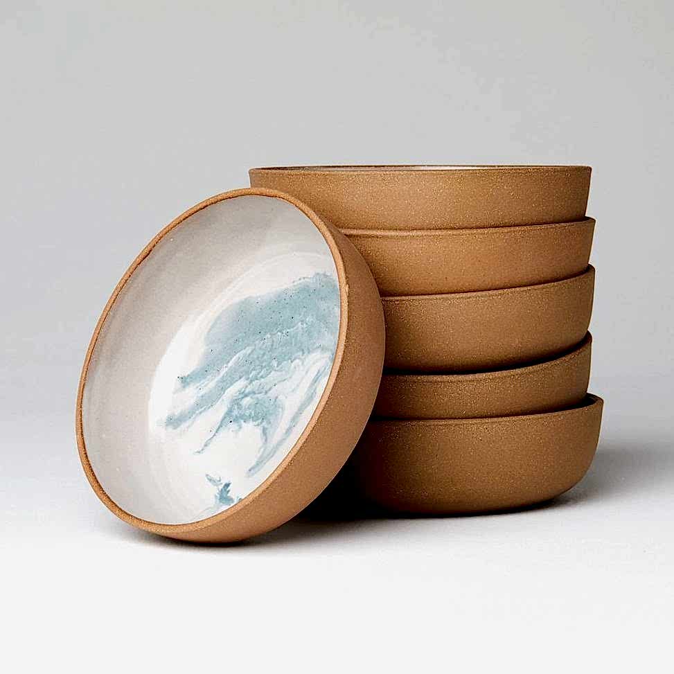 Stack of ceramic bowls with brown exteriors and blue and white marbled interiors