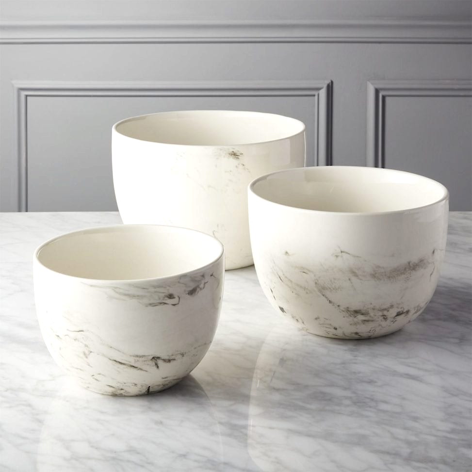 Three marble mixing bowls sitting on marble counter