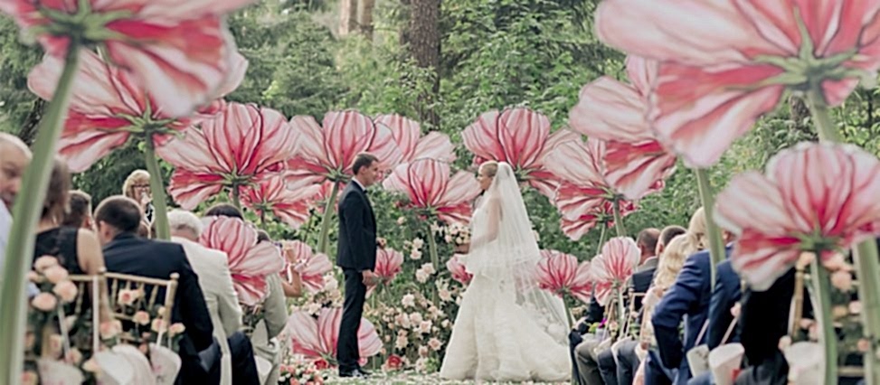 couple standing among large artificial flowers