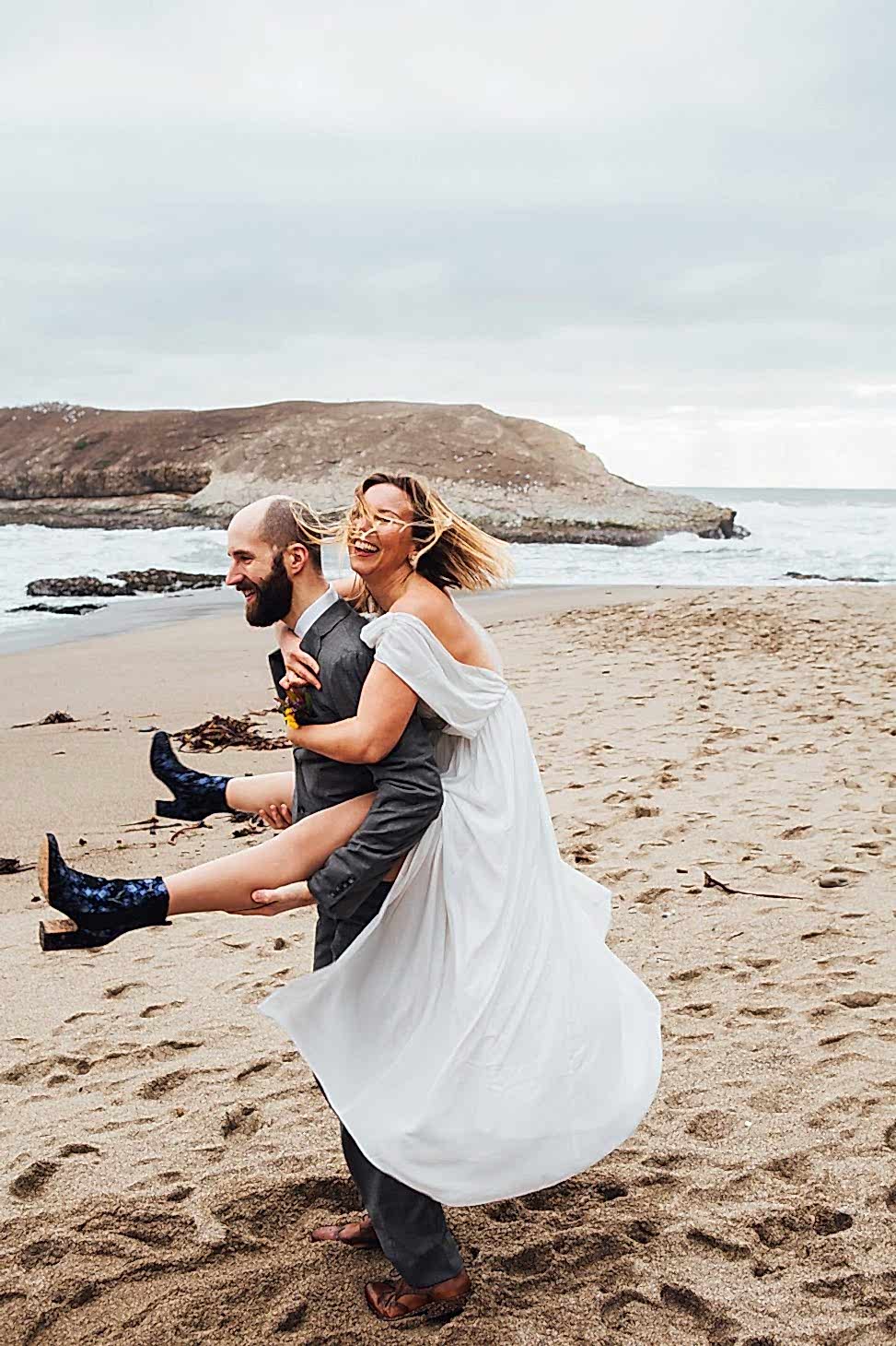 a man carrying a woman on his back on the beach
