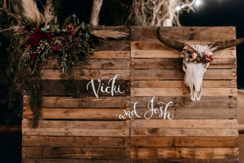 flowers and cattle head on wooden board with couples name on it