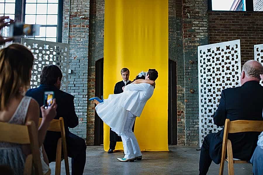 couple embracing in front of a yellow backdrop