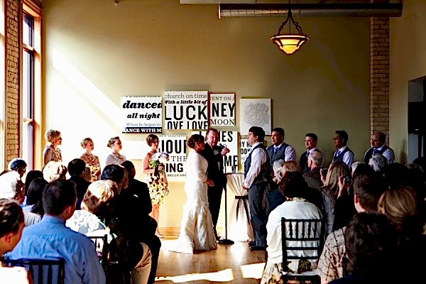 couple getting married in front of typography prints