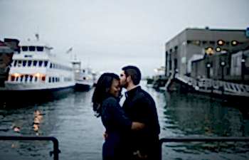 A couple kiss at the river's edge