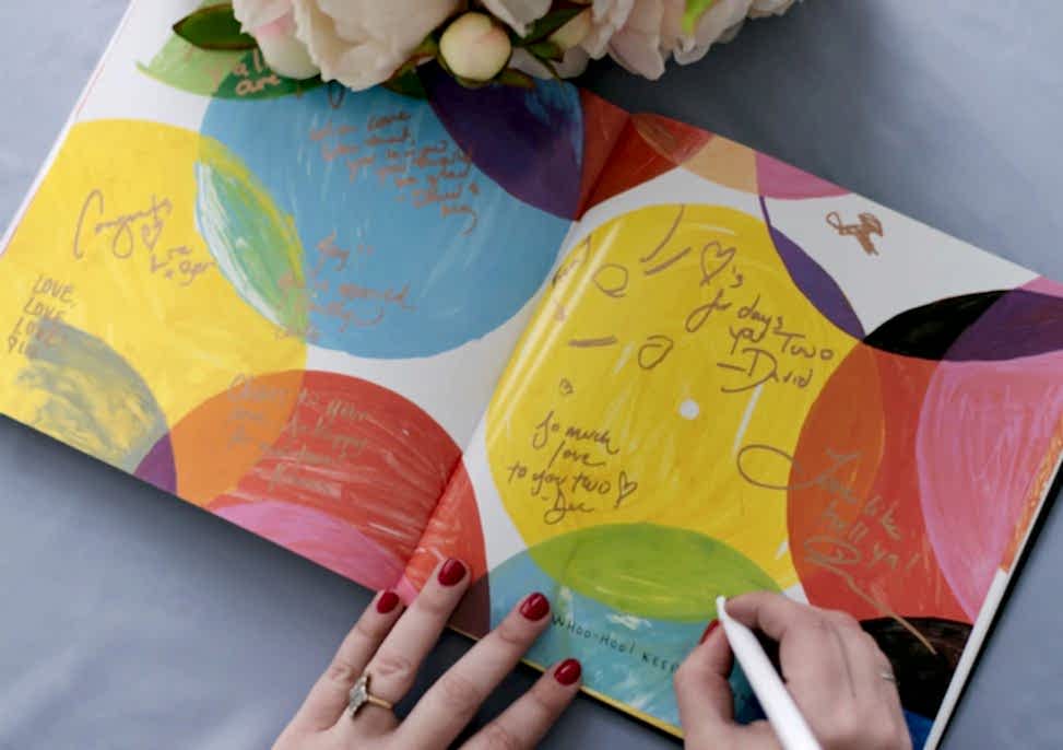 someone signing pages in a children's art book