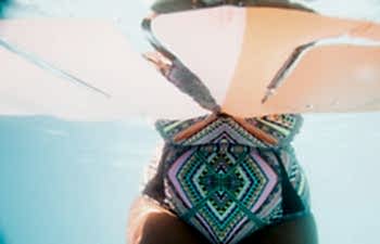 torso of a woman in a colorful swimsuit, under water