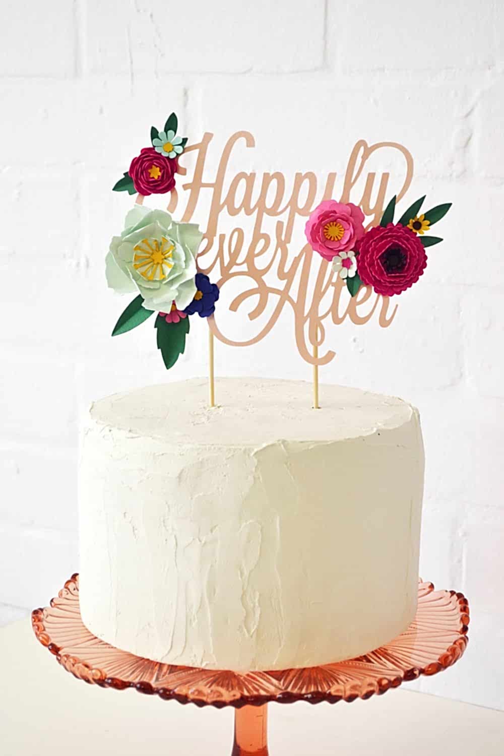 "happily ever after" surrounded by paper flowers cake topper