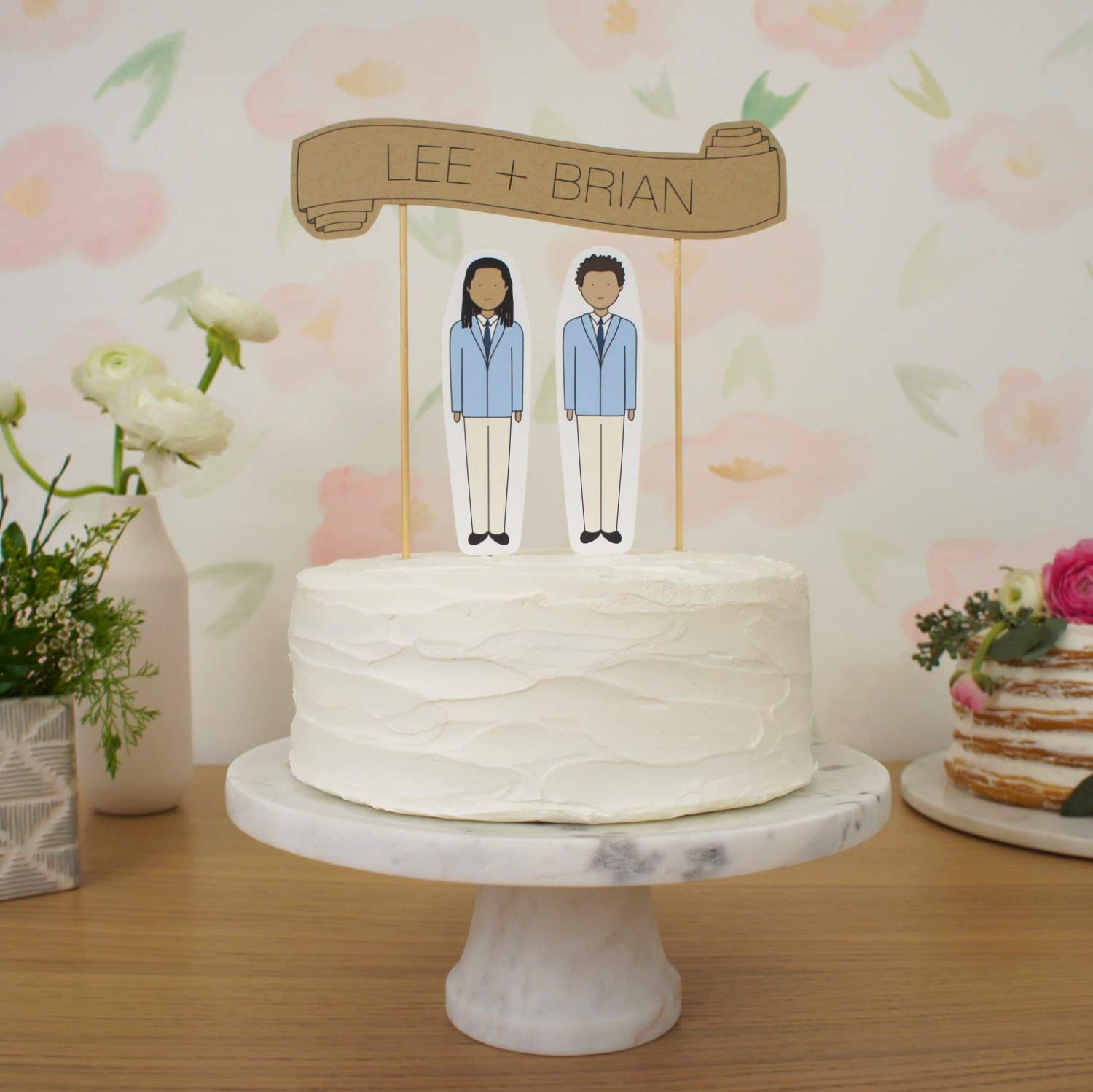 two groom paper dolls on wedding cake