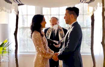 Wedding couple under a chuppah in their living room