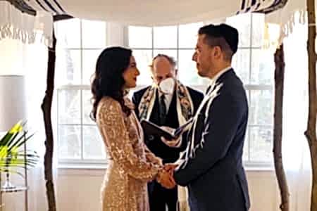 Wedding couple under a chuppah in their living room