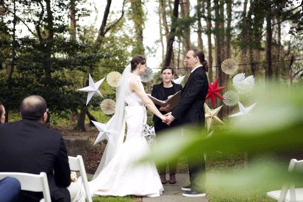 couple reciting their wedding ceremony script at an outdoor wedding