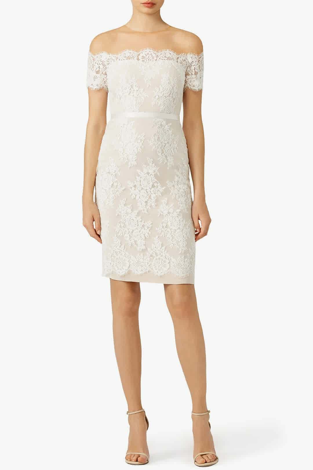 woman wearing a ivory cocktail length sheath dress